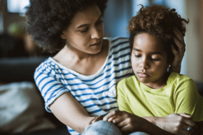 A woman comforts a young child.