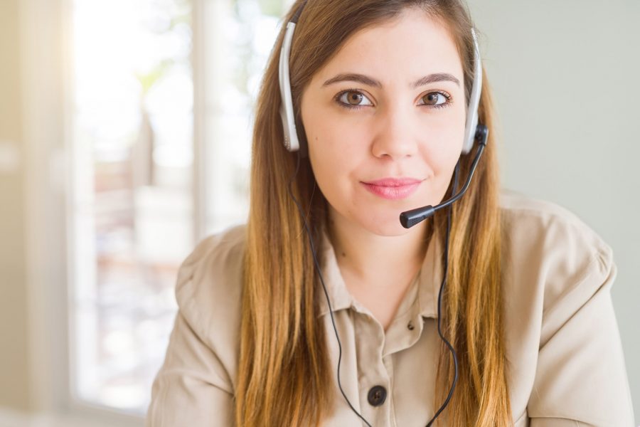 A picture of a call centre agent wearing a headset looking at the camera