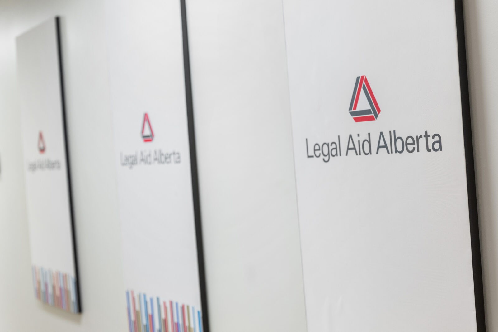 Legal Aid Alberta signs hang on a wall.
